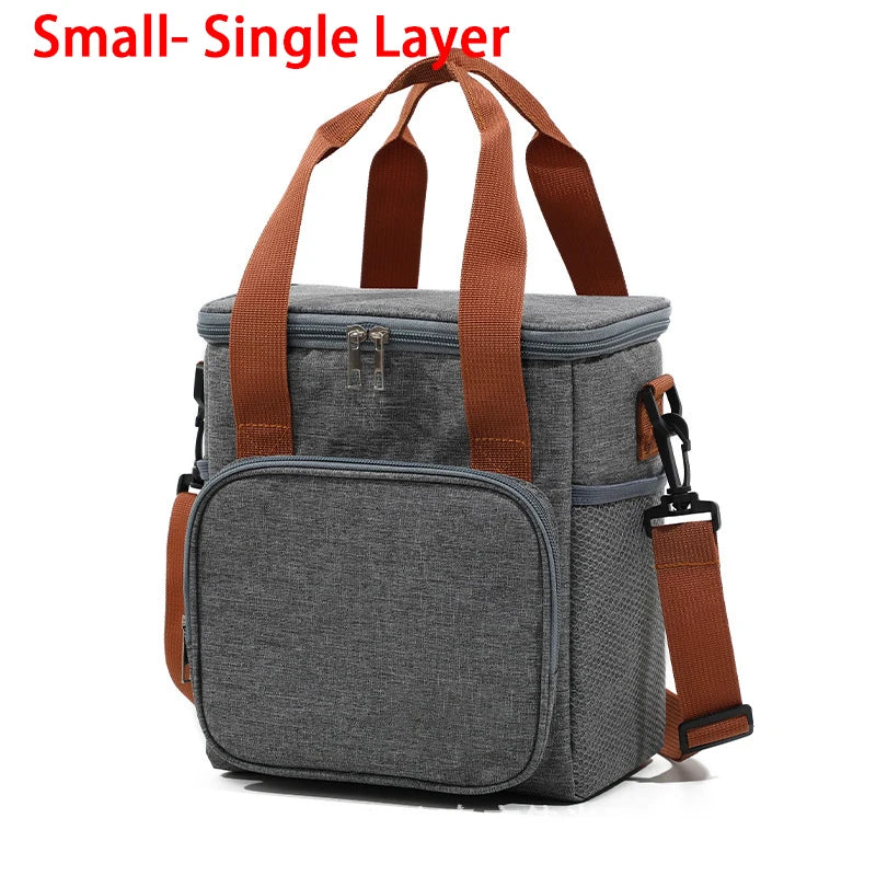 A small, single-layer gray insulated lunch bag with brown straps and a zippered pocket.