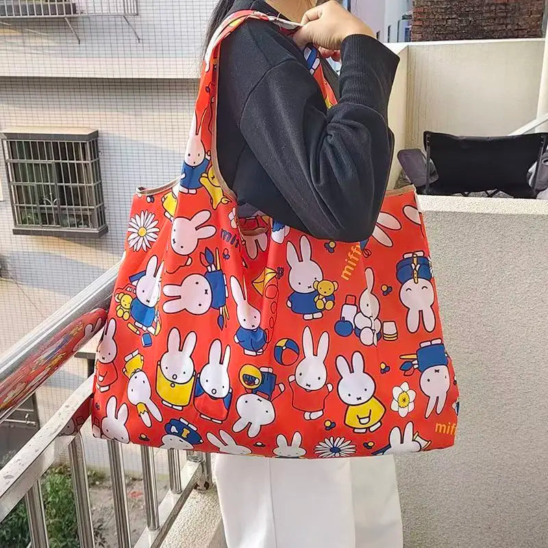 An orange fabric shopping bag featuring repeated illustrations of the character Miffy.