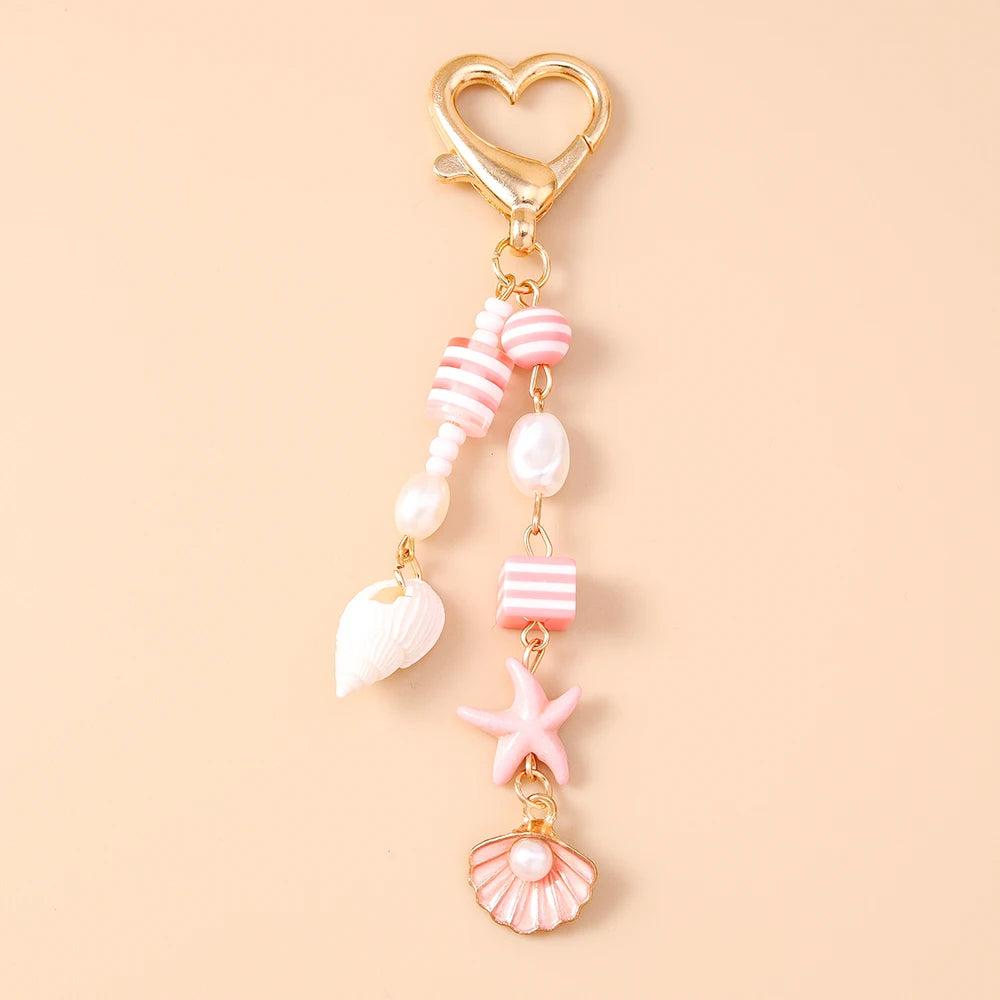 Gold heart-shaped keychain featuring a starfish and pearl accents.
