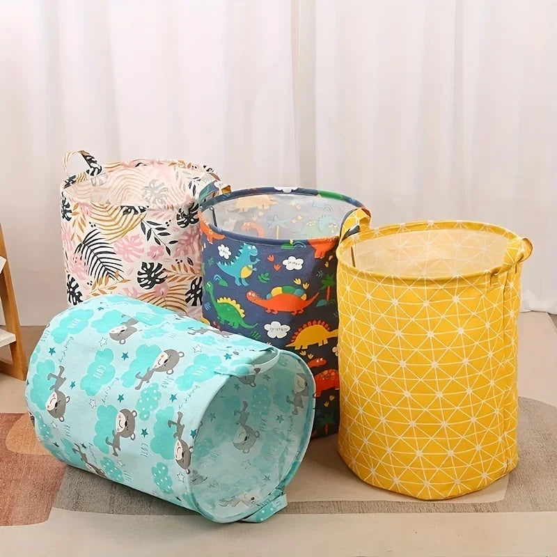 Trois paniers à linge en tissu colorés rose, bleu et jaune sont exposés sur une surface claire.