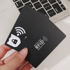 A hand holds a black RFID protection card with a wireless signal icon.