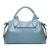 A light blue faux leather Boston handbag with a padded top and gold hardware.