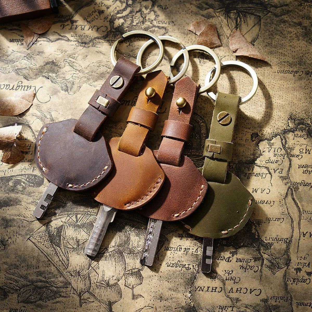A collection of genuine leather key fob covers and keychain rings laid on aged paper.