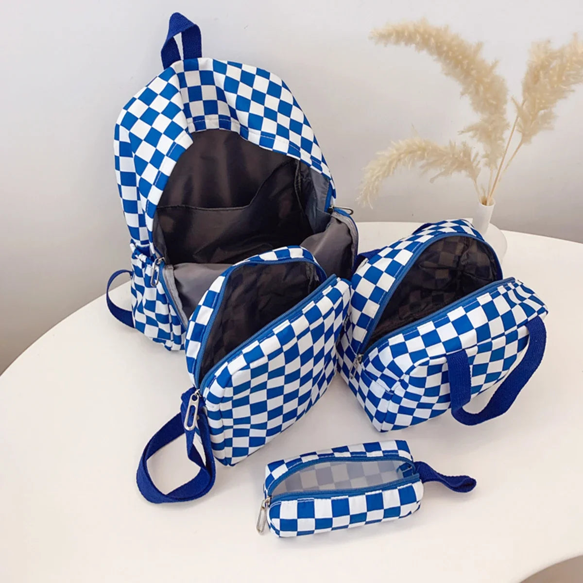 A blue and white checkerboard multi-pocket backpack is displayed on a white surface.