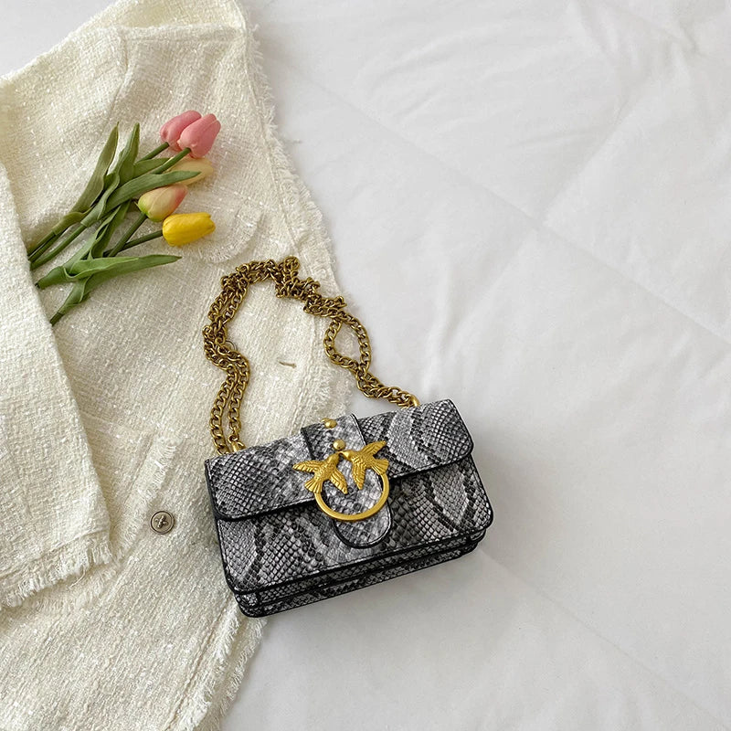 A black and white patterned elegant retro crossbody bag rests on a white linen shirt.