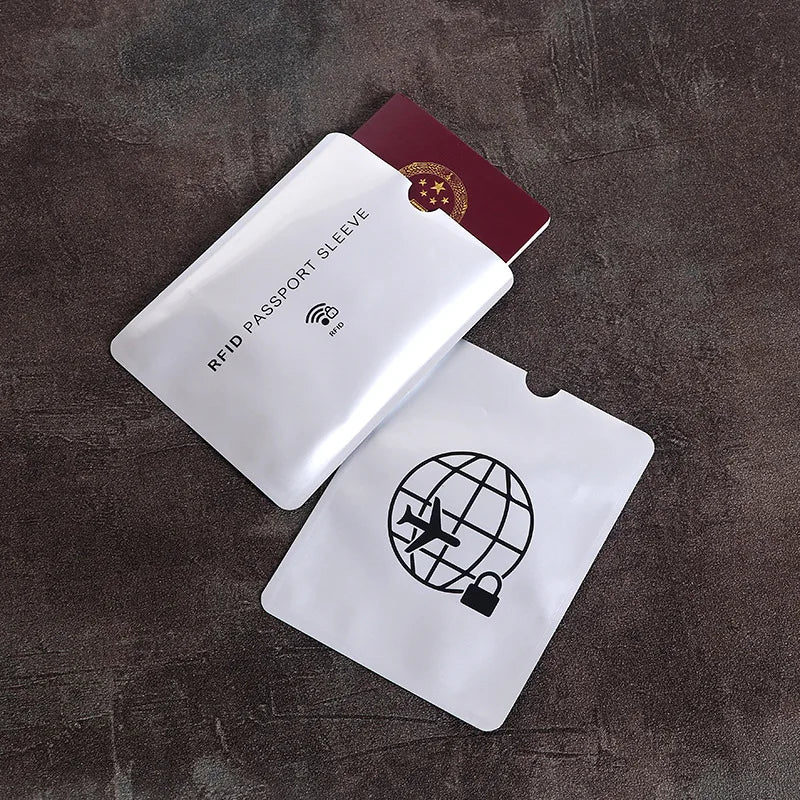 A white RFID passport sleeve is shown next to a maroon card, resting on a dark surface.