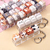 A collection of acrylic cat keycaps and fidget toys in various colors are displayed with metal keychains.