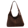 A dark brown suede slouchy shoulder bag with a leather strap and tag.