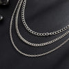 Silver punk star chain belt with pearl accents displayed against a dark background.