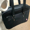 A black women's Japanese style PU shoulder bag with a large capacity, shown from the side.