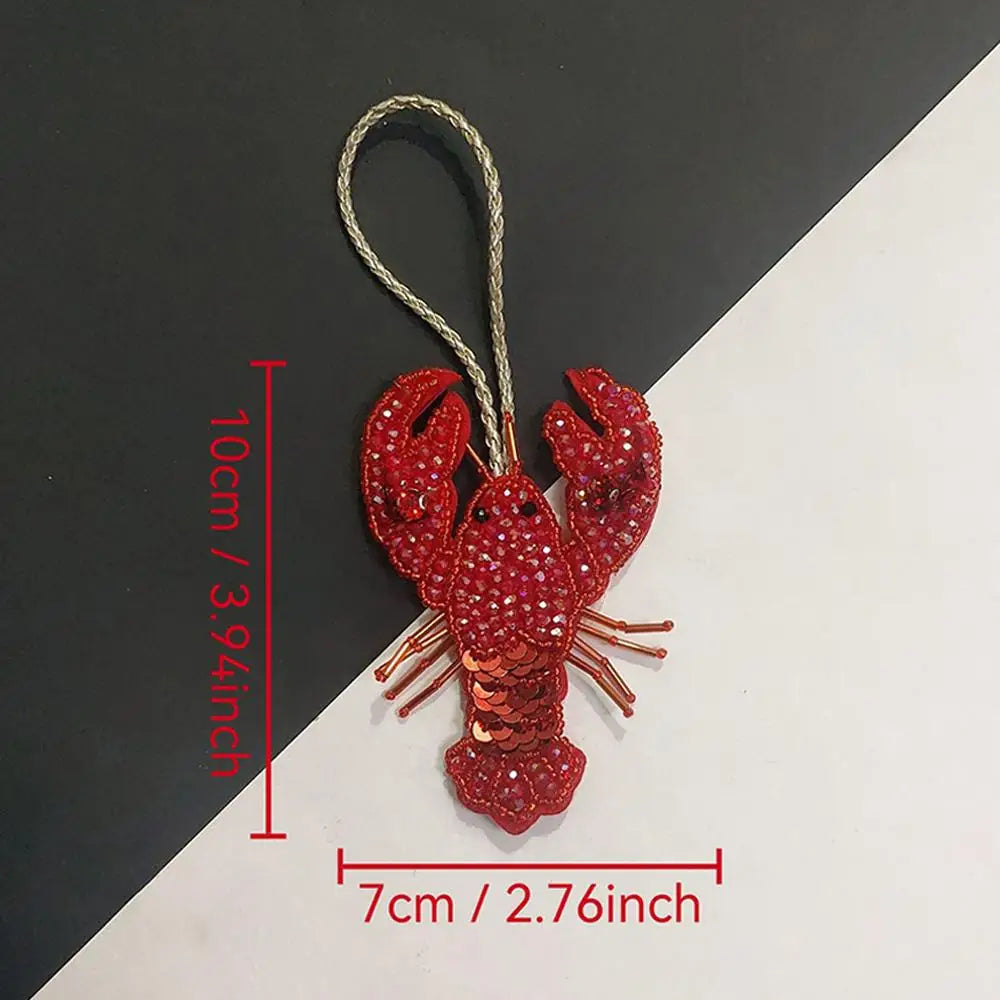 A hand sewn rhinestone beaded bag charm shaped like a crab, measuring 10cm long.