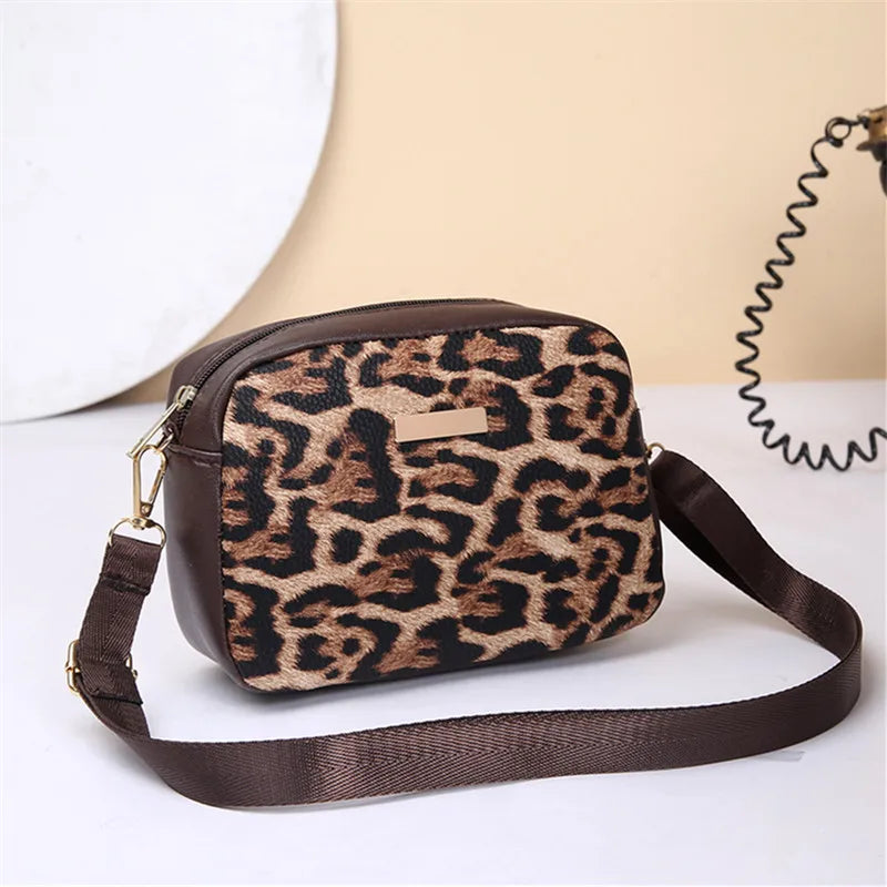 A brown leopard print crossbody bag with a dark brown strap is displayed on a white surface.