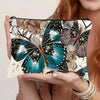 Bolsa de almacenamiento con cremallera de lienzo con estampado de mariposa en tonos verde azulado, negro y beige.