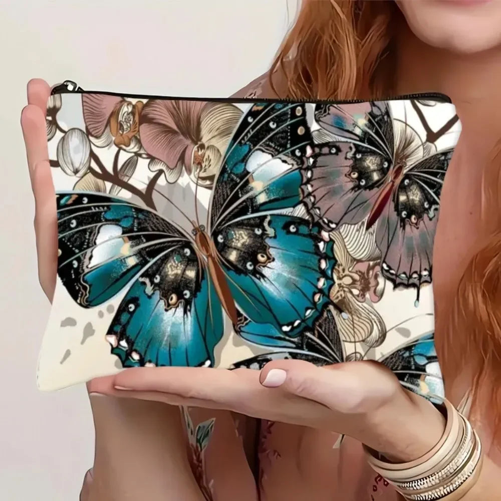 Bolsa de almacenamiento con cremallera de lienzo con estampado de mariposa en tonos verde azulado, negro y beige.