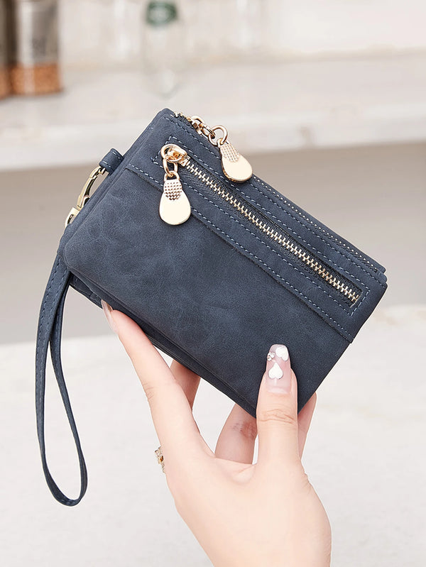 A hand holds a dark blue retro folding zipper PU leather wallet with gold hardware.