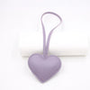 A small lavender PU leather heart shaped keychain with a loop for attachment.