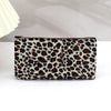 A brown and beige leopard print zippered cosmetic bag lying on a white surface.