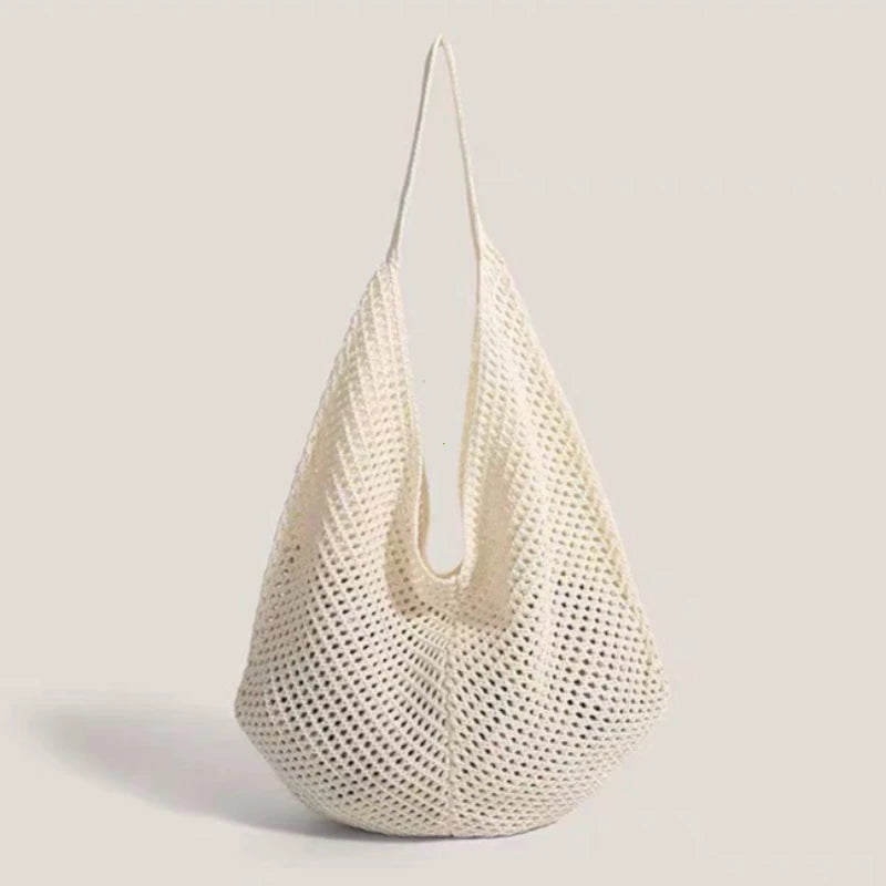 A cream-colored crochet shoulder bag with a mesh detailing, shown against a light background.