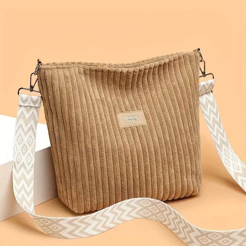Sac à épaule et bandoulière en velours côtelé beige avec une sangle à motif blanc, présenté sur fond clair.