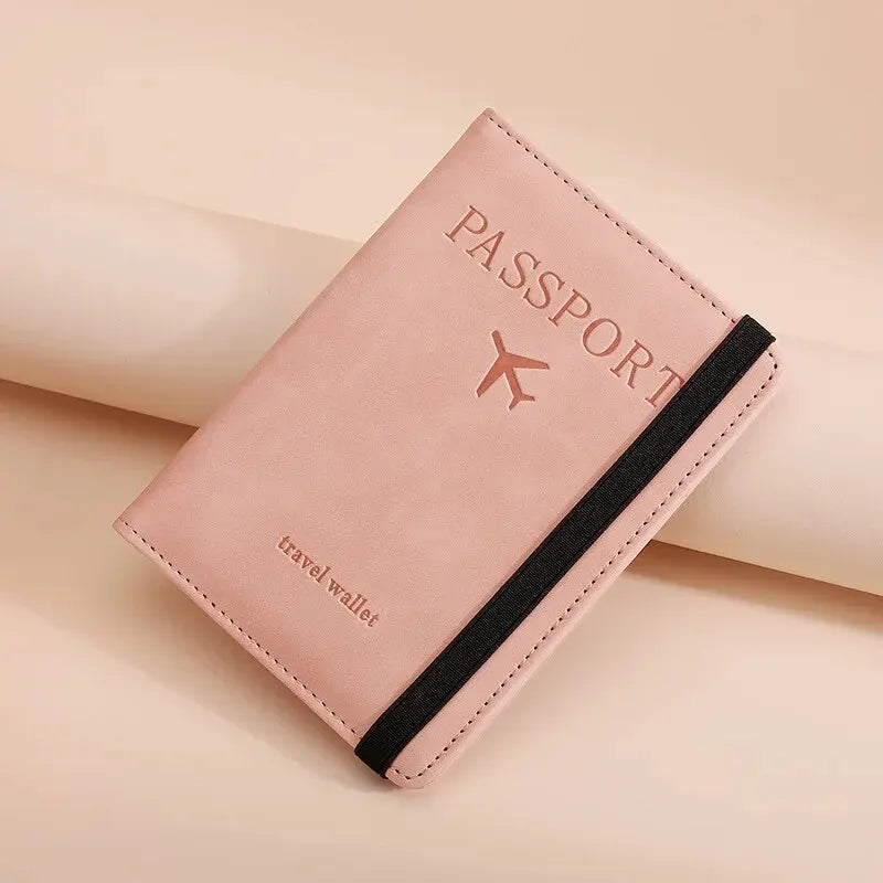 A pink passport wallet with black trim and a silver airplane logo resting on a light background.