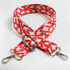 Red and beige jacquard patterned adjustable crossbody bag strap with silver hardware