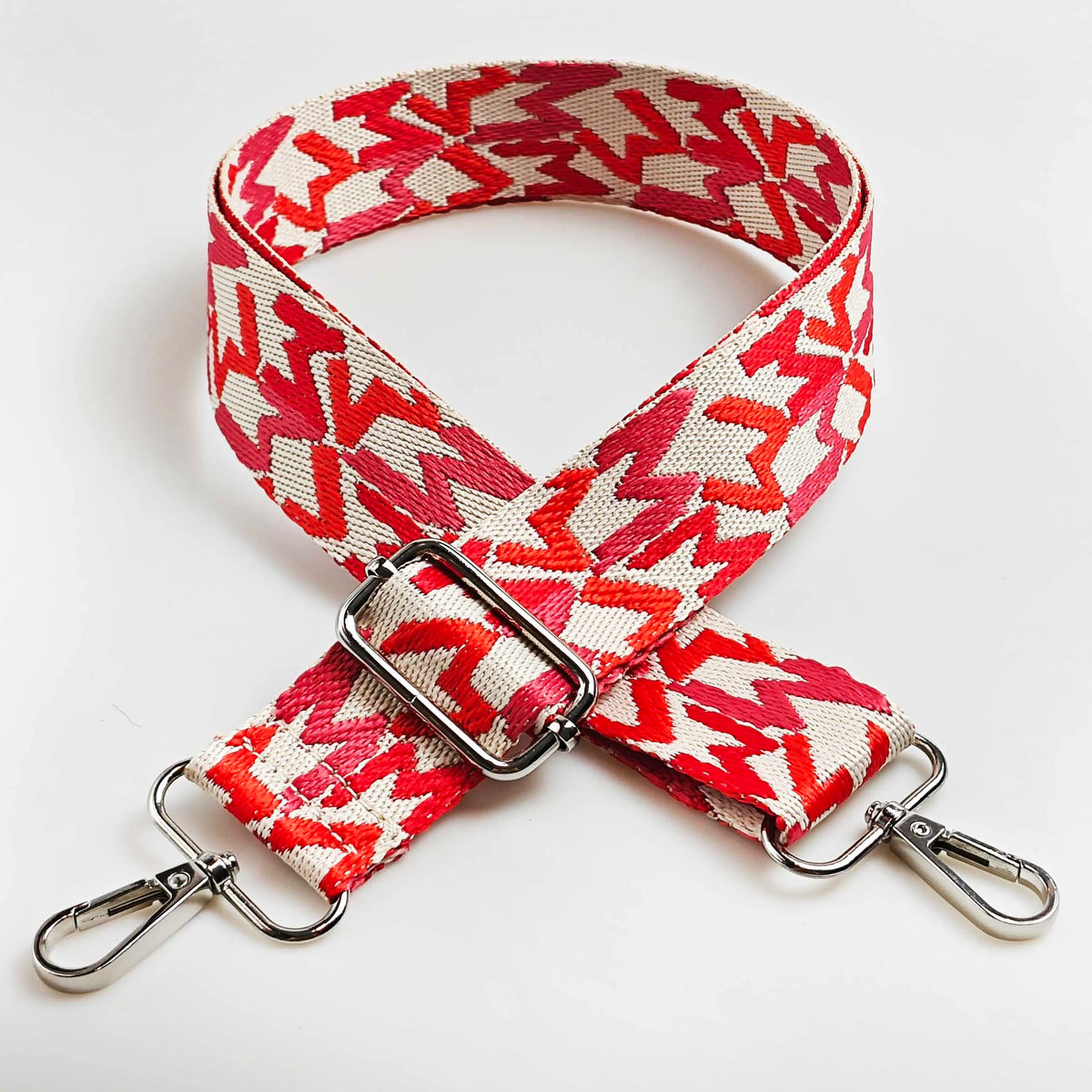 Red and beige jacquard patterned adjustable crossbody bag strap with silver hardware