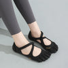 A pair of black women's barefoot five-toe shoes with adjustable straps shown on a person's foot.