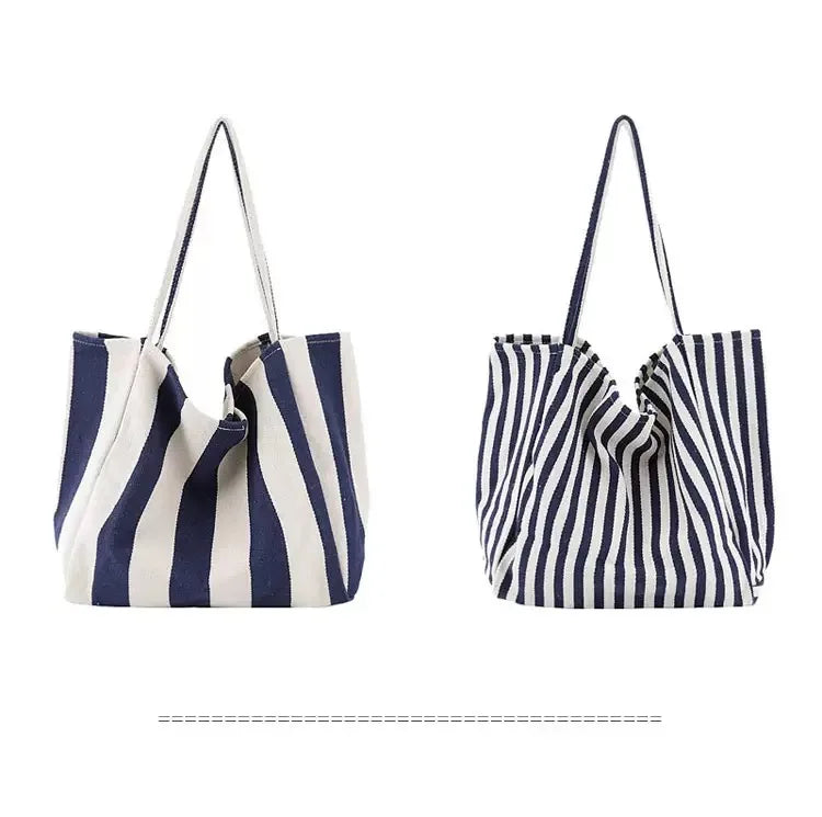 A striped canvas tote bag featuring vertical navy and white stripes with a gathered top design.