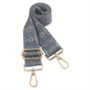 A dark blue patterned nylon crossbody bag strap with gold hardware.