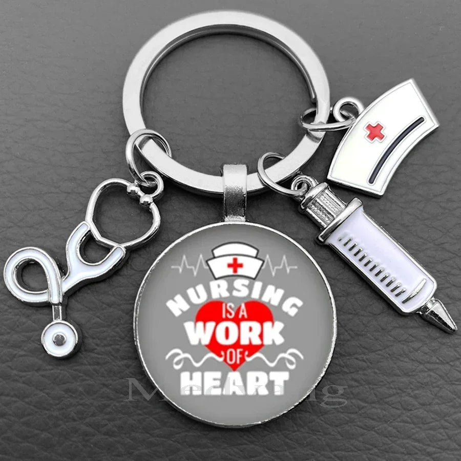 Silver keychain featuring a stethoscope charm and a circular pendant with the text Nursing is a work of heart