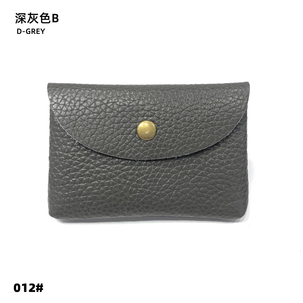 A dark grey genuine leather card holder or coin purse with a gold-toned clasp.