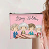 Bolsa de almacenamiento cosmético rosa con cremallera que dice 'Stay Golden' e ilustraciones de cuatro mujeres diversas.