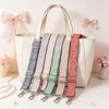 A beige tote bag with multiple adjustable nylon shoulder straps in various patterns and colors