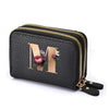 Black mini wallet with a gold zipper featuring a large floral letter M print