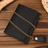 Black men's genuine leather trifold wallet with a gold chain resting on a wooden surface.