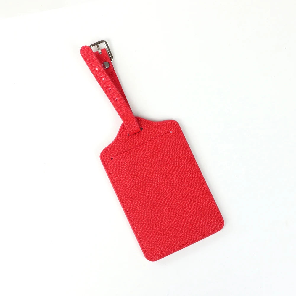 A bright red PU leather luggage tag with a silver clip attached to a strap.