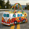 A vintage sunflower quilted duffle bag with colorful floral embroidery and striped fabric handles resting on asphalt.
