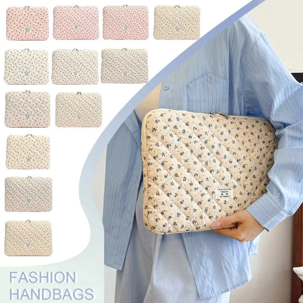 A beige quilted laptop sleeve in a floral pattern is shown being carried by a person wearing a light blue shirt.