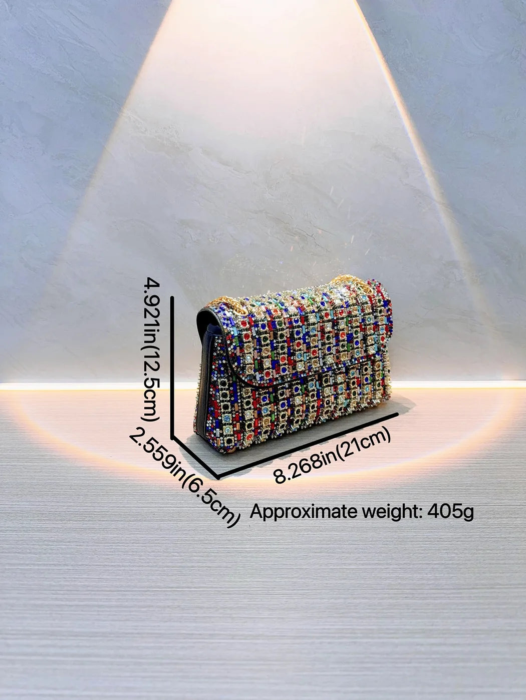 A sparkling rhinestone leather evening clutch bag is displayed under a spotlight.