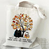 A white canvas tote bag featuring a black cat and butterfly illustration on the front.