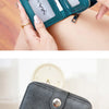 A close-up of a teal RFID blocking multi-function women's wallet with a zippered compartment being held by a hand.
