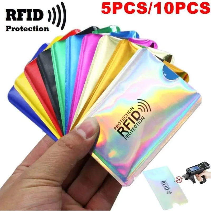 Una mano sostiene una pila de fundas de tarjetas RFID bloqueadoras y coloridas para protección, con una funda visible.