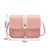A light pink fashion square crossbody bag with a cream strap and gold chain detail.