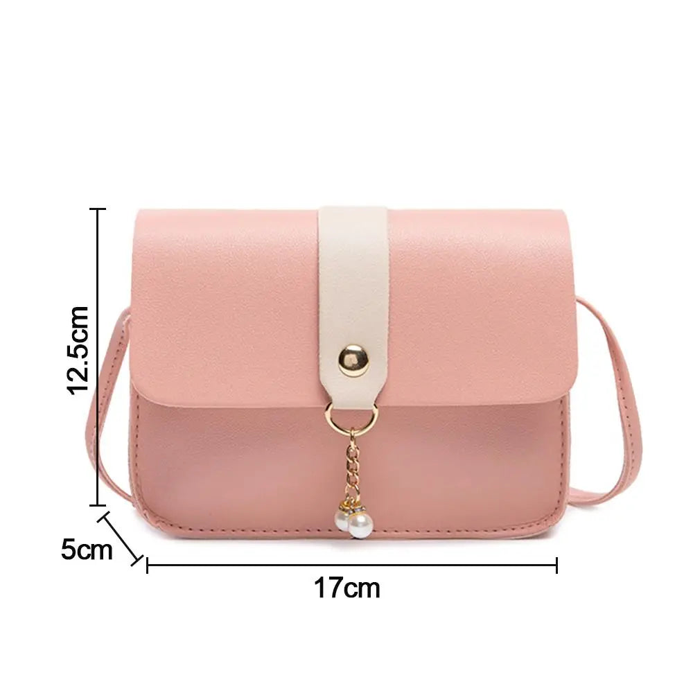 A light pink fashion square crossbody bag with a cream strap and gold chain detail.