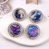 Four silver folding table bag hooks with marbled blue and purple gemstone designs on a white plate
