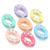 A collection of colorful acrylic link chains in lavender, yellow, mint green, peach, and blue, each adorned with small clear 