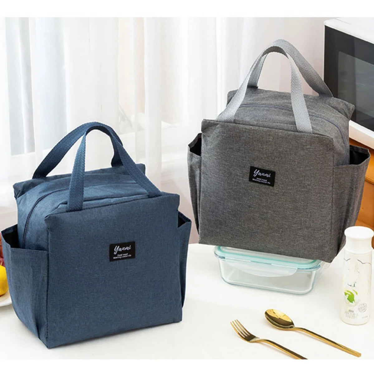 A dark blue insulated canvas tote bag with double pockets is shown on a white surface.