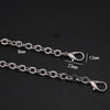 Silver metal chain strap with adjustable links and lobster clasps shown against a black background.
