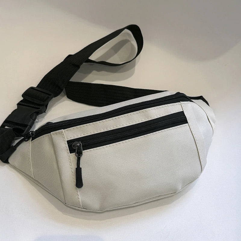 A light beige compact nylon waist bag with black straps and a zippered compartment.