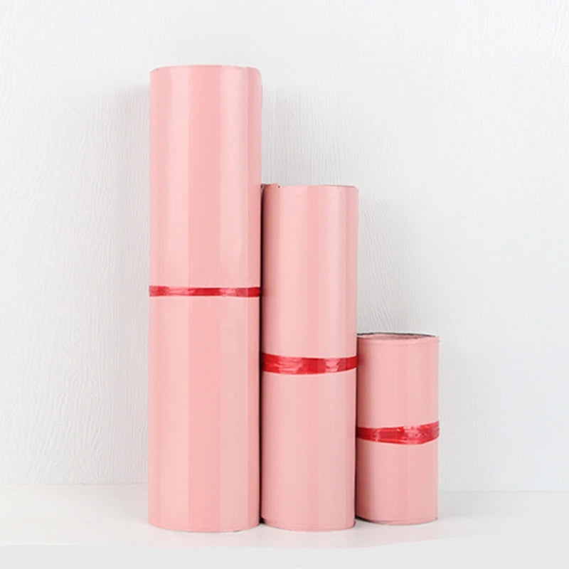 Tres bolsas de almacenamiento rosadas autoadhesivas de pie contra un fondo blanco.